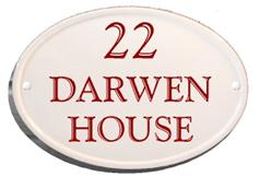 oval house sign with burgundy writing